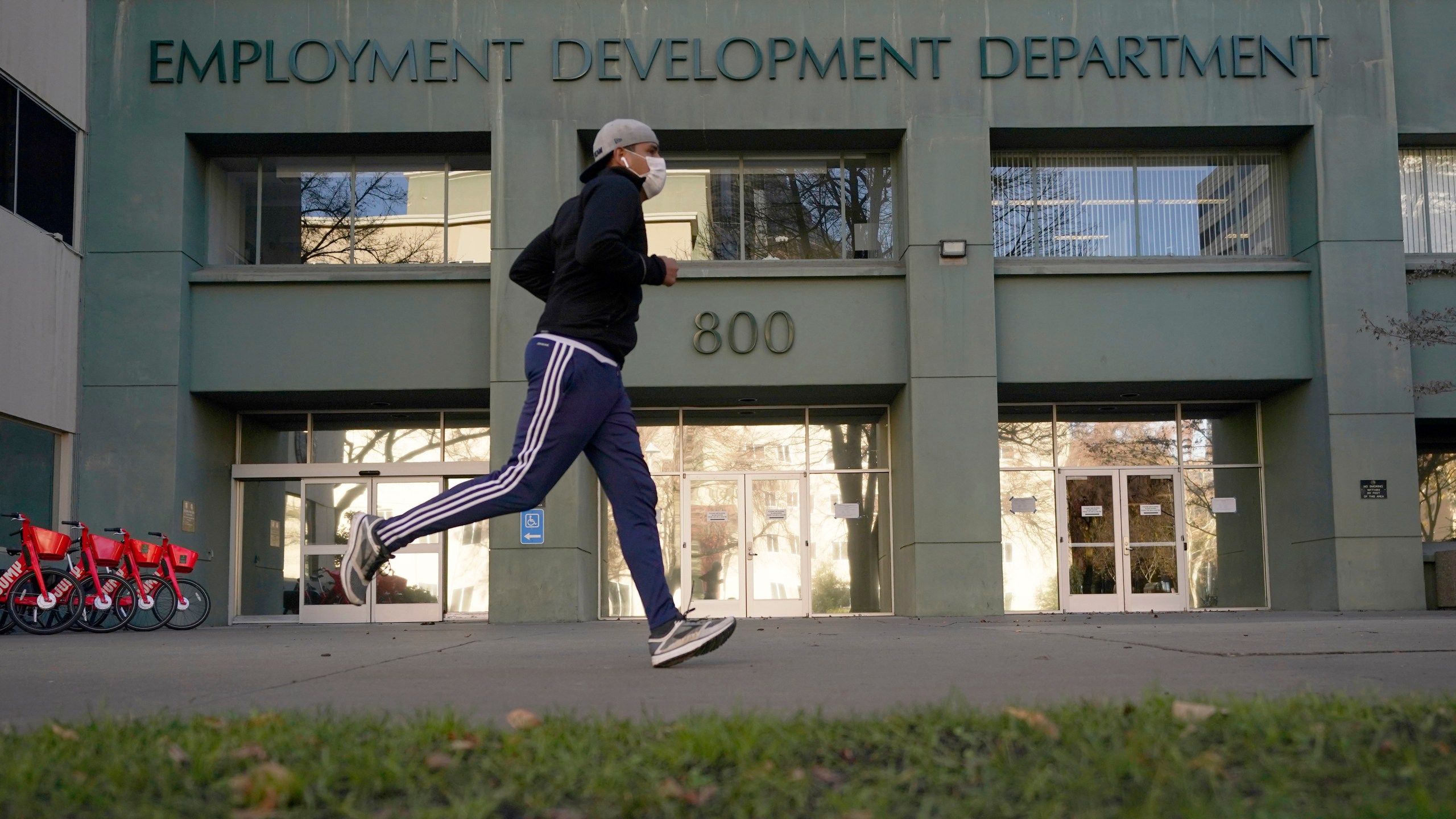 A runner passes the office of the California Employment Development Department in Sacramento, Calif., on Dec. 18, 2020. (Rich Pedroncelli/Associated Press)