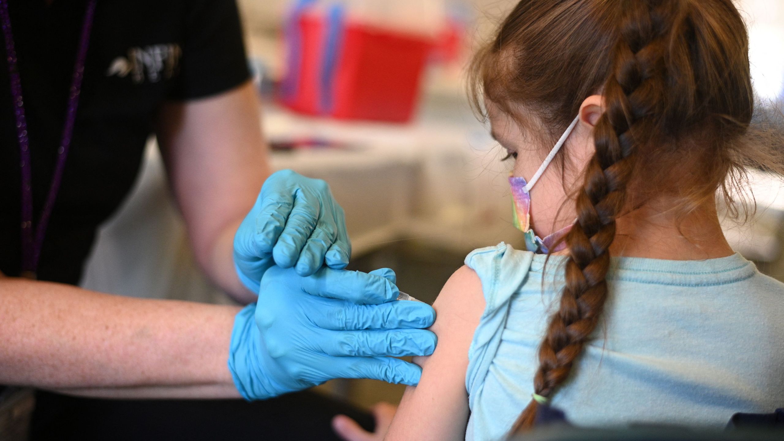 A nurse administers a pediatric dose of the Covid-19 vaccine to a girl at a L.A. (ROBYN BECK/AFP via Getty Images)