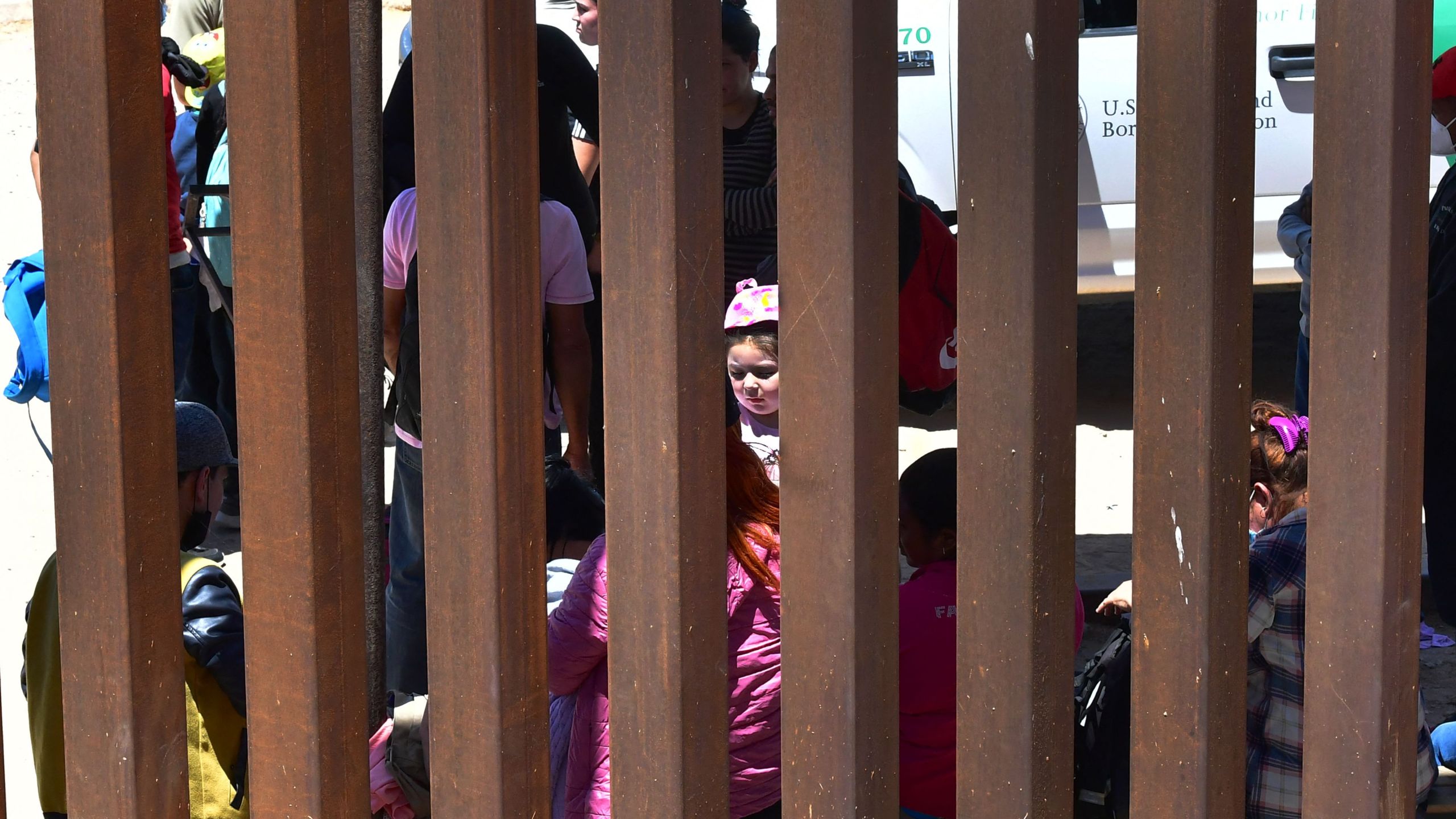 Migrants await processing by U.S. Border Patrol officers after attempting to cross from Algodones, Mexico to Yuma, Arizona on May 16, 2022. (FREDERIC J. BROWN/AFP via Getty Images)