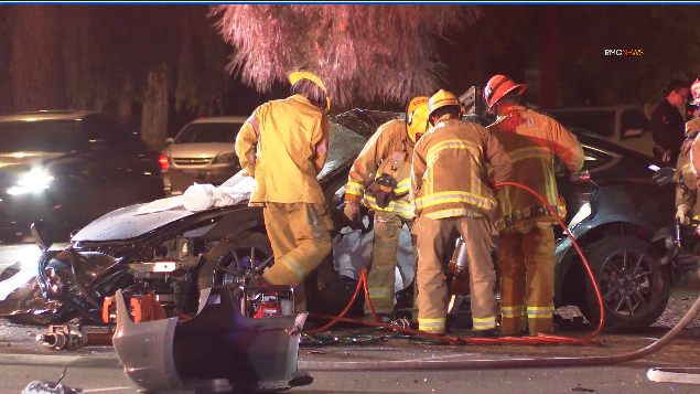 Firefighters work on a Tesla after a fatal hit-and-run crash in Lake Balboa on May 28, 2022. (RMG News)