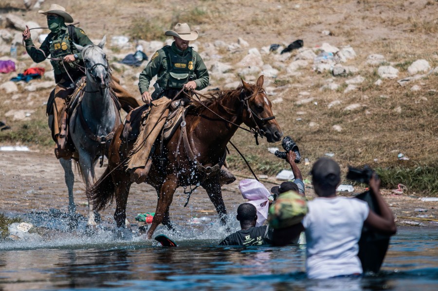 Mounted U.S. Border Patrol agents attempt to contain migrants as they cross the Rio Grande from Ciudad Acuña, Mexico, into Del Rio, Texas on Sept. 19, 2021. (Felix Marquez/Associated Press)