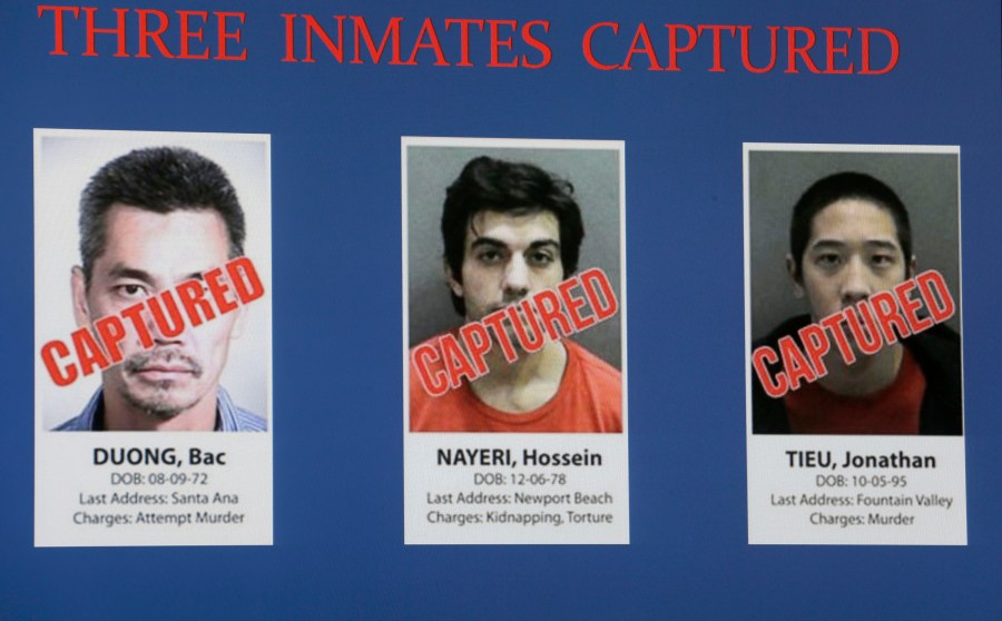 Three captured inmates, from left to right: Bac Tien Duong, Hossein Nayeri, and Jonathan Tieu, are displayed on a video monitor at an Orange County Sheriff's news conference in Santa Ana, Calif., Feb. 1, 2016. One of three men who carried out a daring, elaborate escape from a Southern California jail has been sentenced to 20 years in prison. Duong, 49, was sentenced both for the 2016 breakout and for attempted murder in the case that first got him locked up. (AP Photo/Nick Ut, File)