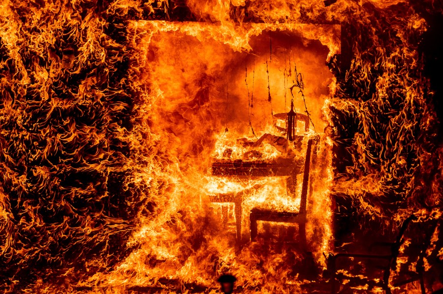 Flames engulf a chair inside a burning home as the Oak Fire burns in Mariposa County, Calif., on Saturday, July 23, 2022. (AP Photo/Noah Berger)