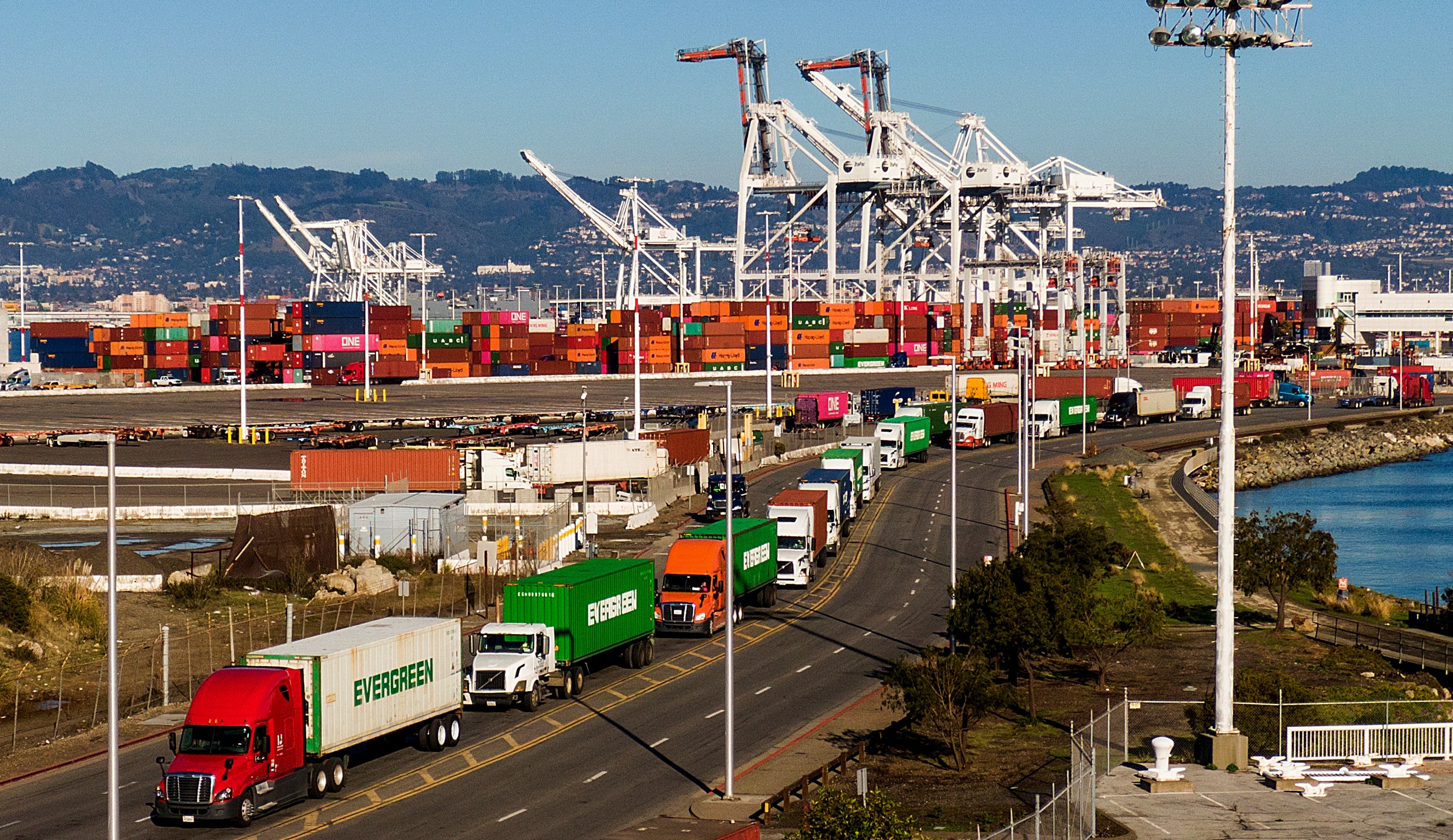 Trucks line up to enter a Port of Oakland shipping terminal on Nov. 10, 2021, in Oakland, Calif. Truckers protesting a state labor law have effectively shut down cargo operations at the Port of Oakland, it was announced Wednesday, July 20, 2022. The protest that began Monday, July 18 involves hundreds of independent big-rig truckers that have blocked the movement of cargo in and out of terminals at the port, which is one of the 10 busiest container ports in the country. (AP Photo/Noah Berger, File)