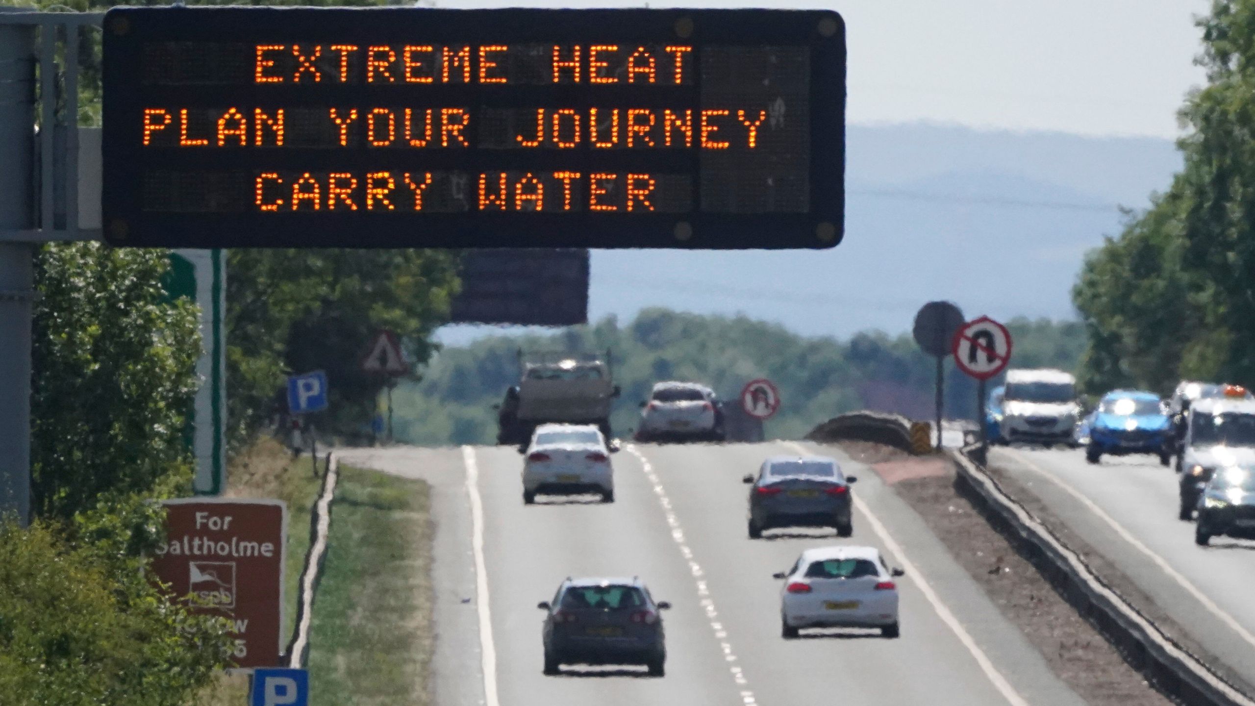 A matrix sign over the A19 road towards Teesside displays an extreme weather advisory as the UK braces for the upcoming heatwave, in England, Saturday July 16, 2022. (Owen Humphreys/PA via AP)