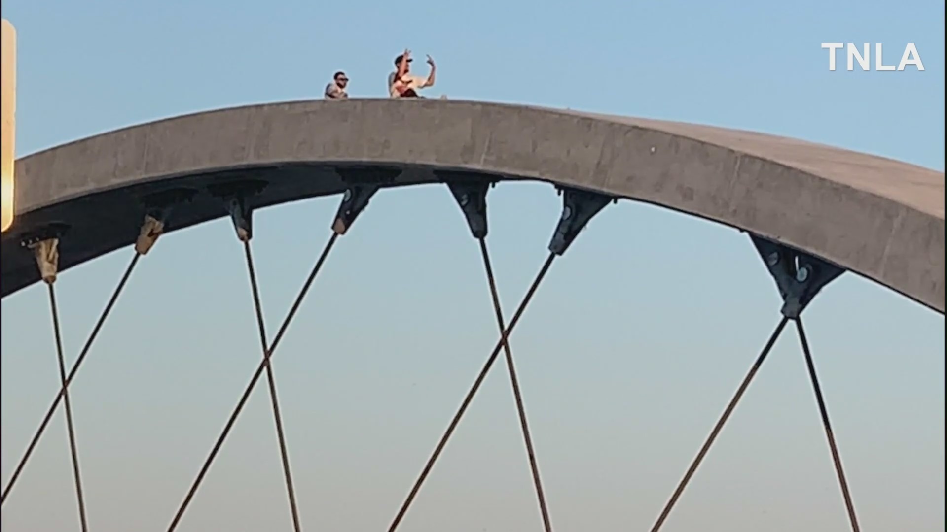 Spectators sit atop the 6th Street Bridge as vehicles drift and do burnouts on July 17, 2022. (TNLA)