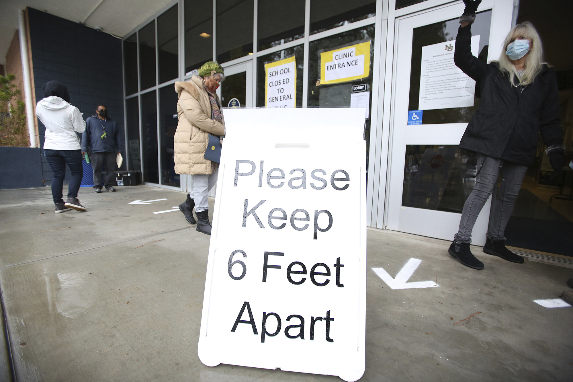 A sign asks those getting vaccinated to keep 6 feet apart during the vaccination event at Nevada Union High School in Grass Valley, Calif on Jan. 27, 2021. (Elias Funez/The Union via AP, File)