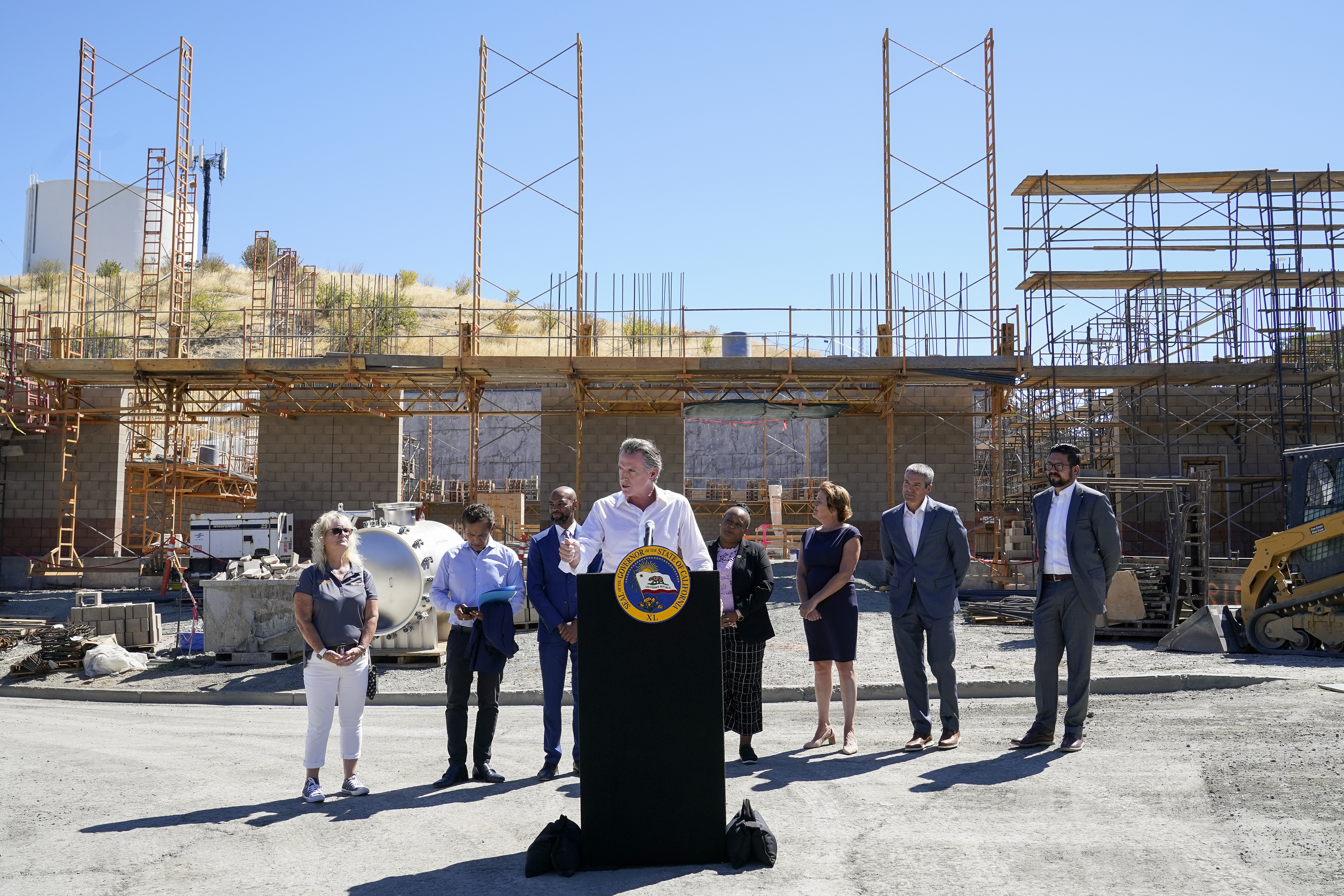 Gov. Gavin Newsom, center, talks to reporters during a press conference at the construction site of a water desalination plant in Antioch, Calif., Thursday, Aug. 11, 2022. (AP Photo/Godofredo A. Vásquez)