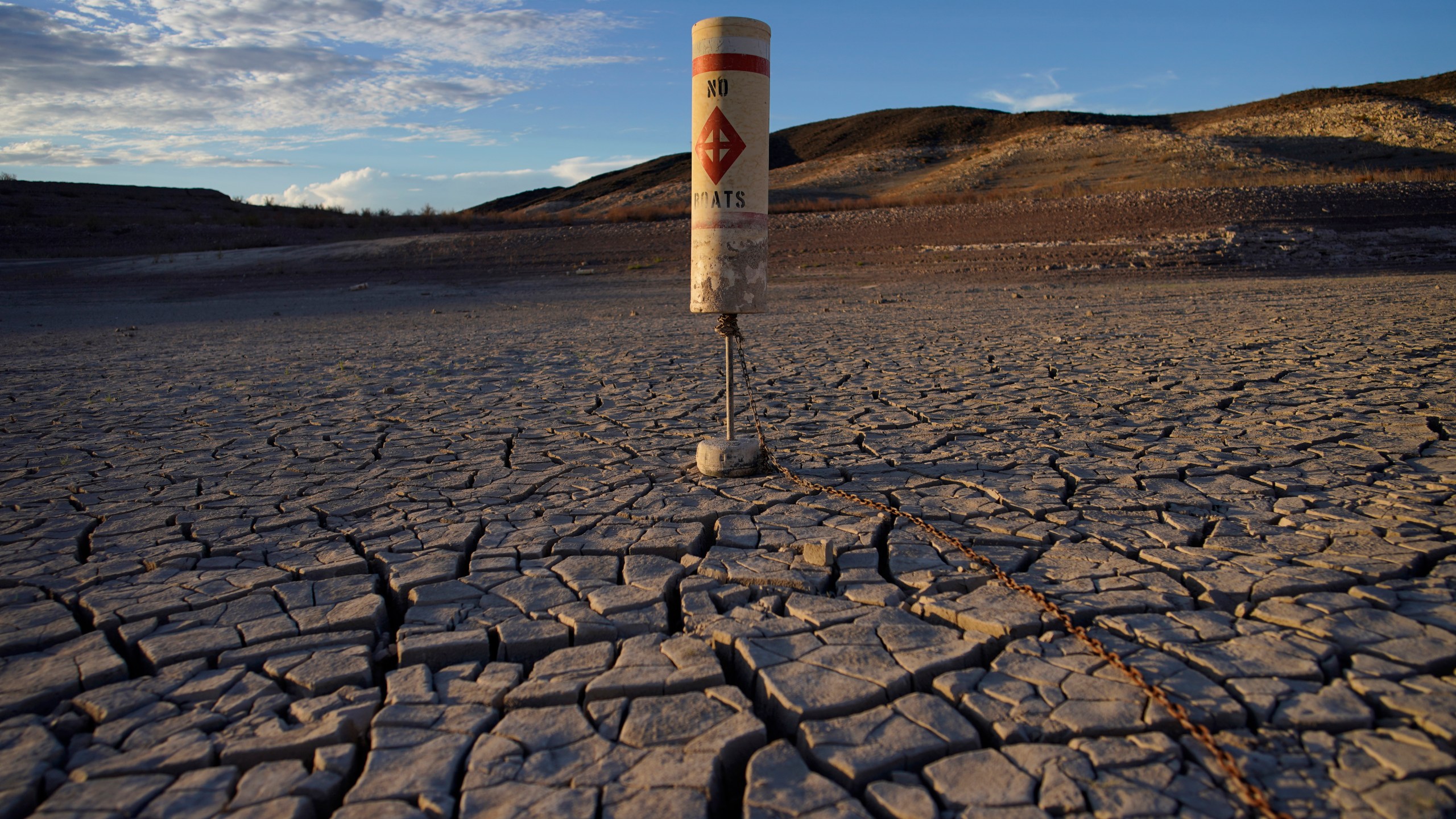 A buoy sits high and dry on cracked earth previously under the waters of Lake Mead at the Lake Mead National Recreation Area near Boulder City, Nev., on June 28, 2022. (John Locher/Associated Press)