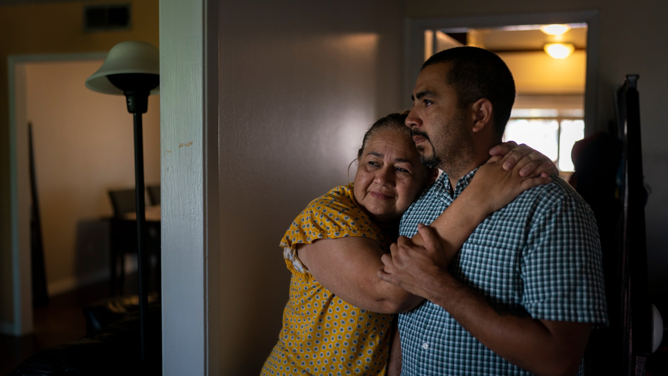 Ana Sandoval, mother of Eyvin Hernandez, a Los Angeles attorney who has been detained for five months in Venezuela, hugs her son Henry Martinez, Hernandez's half-brother, while posing for photos in Compton, Calif., Monday, Aug. 29, 2022. The Los Angeles attorney detained for five months in Venezuela is pleading for help from the Biden administration, saying in a secretly recorded jailhouse message that he feels forgotten by the U.S. government as he faces criminal charges at the hands of one of the nation's top adversaries. (AP Photo/Jae C. Hong)