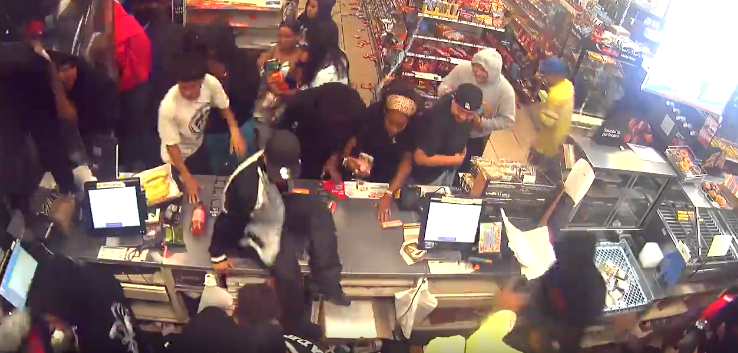 Several people rush the counter at a 7-Eleven during a street takeover in the Harbor Gateway area of Los Angeles on Aug. 15, 2022. (LAPD)