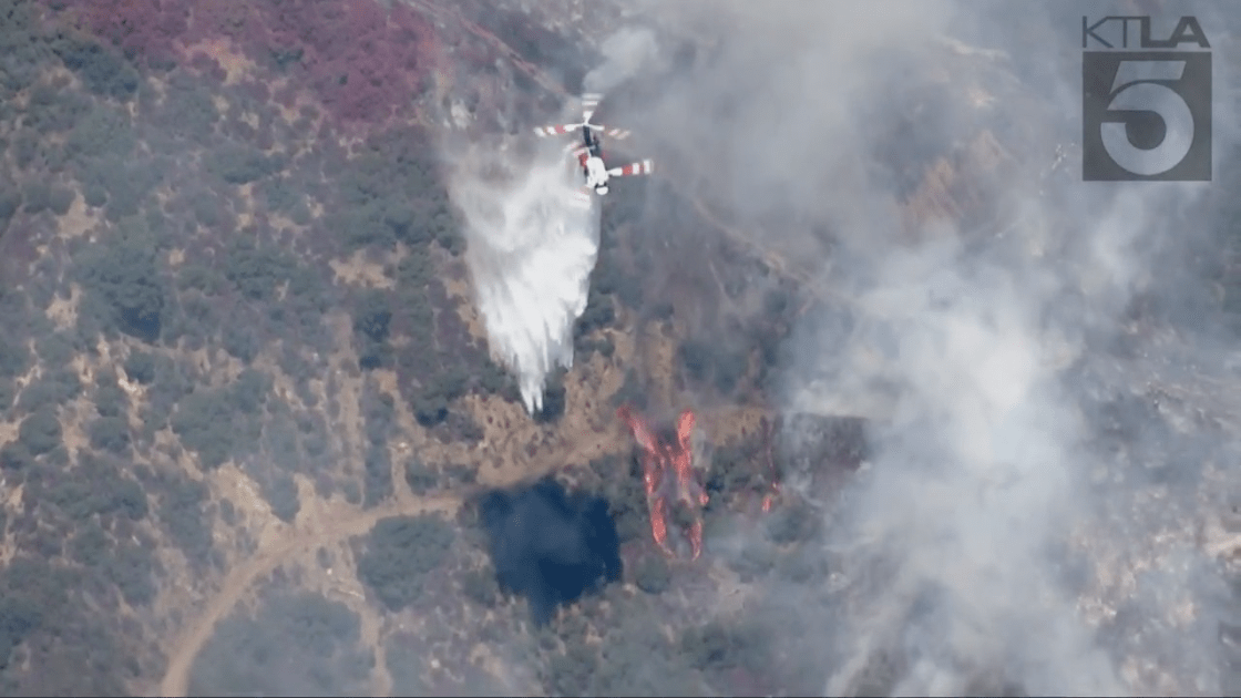 A helicopter makes a water drop on the Gulch Fire on Aug. 29, 2022. (KTLA)