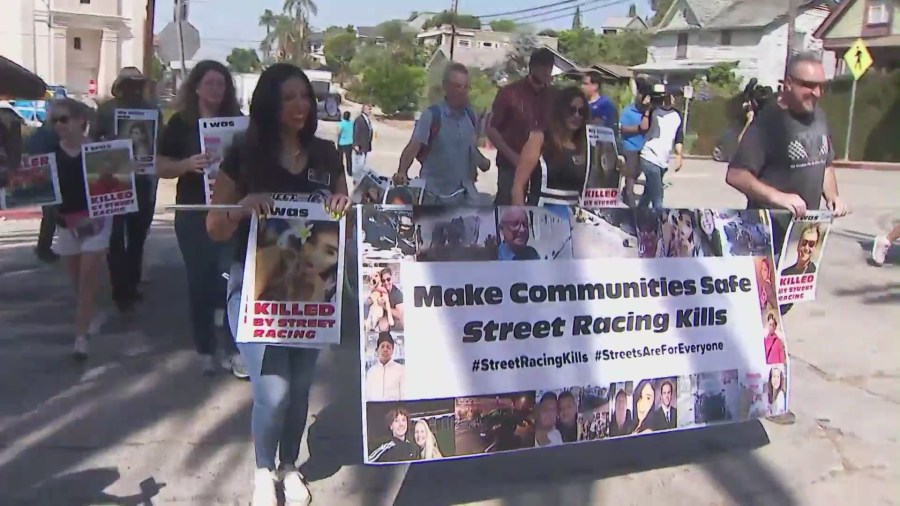 Demonstrators hold signs and photos of loved ones who have died in street racing crashes at Friday's "Fast & Furious" protest. Aug. 26, 2022