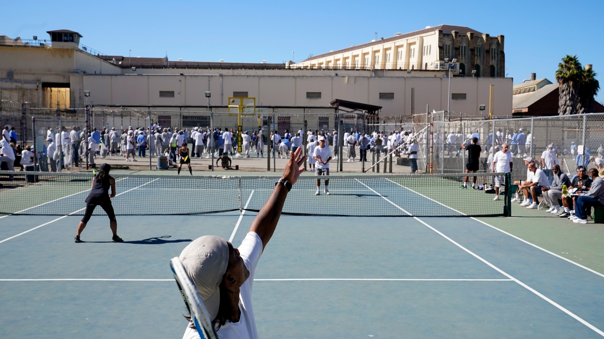 James Duff, bottom, serves during a tennis match between fellow San Quentin State Prison inmates and visiting players in San Quentin, Calif., Saturday, Aug. 13, 2022. (AP Photo/Godofredo A. Vásquez)