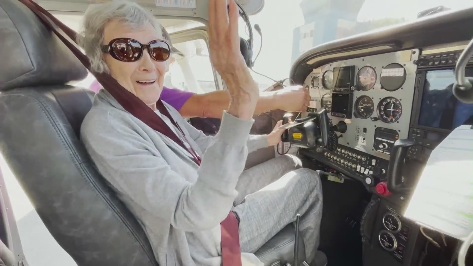 A 99-year-old woman sitting in an airplane cockpit at Torrance Airport