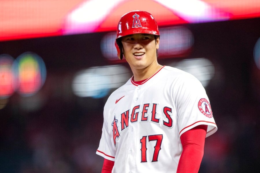 Los Angeles Angels designated hitter Shohei Ohtani smiles while at third base during the first inning of the team's baseball game against the Texas Rangers in Anaheim, Calif., Friday, Sept. 30, 2022