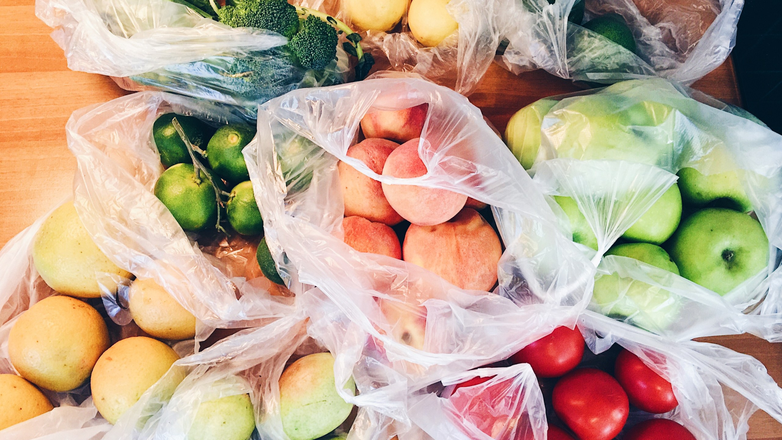 Apples, peachs, tomatoes, pears, cucumbers, avocado packed in plastic bags after shopping at local eco market