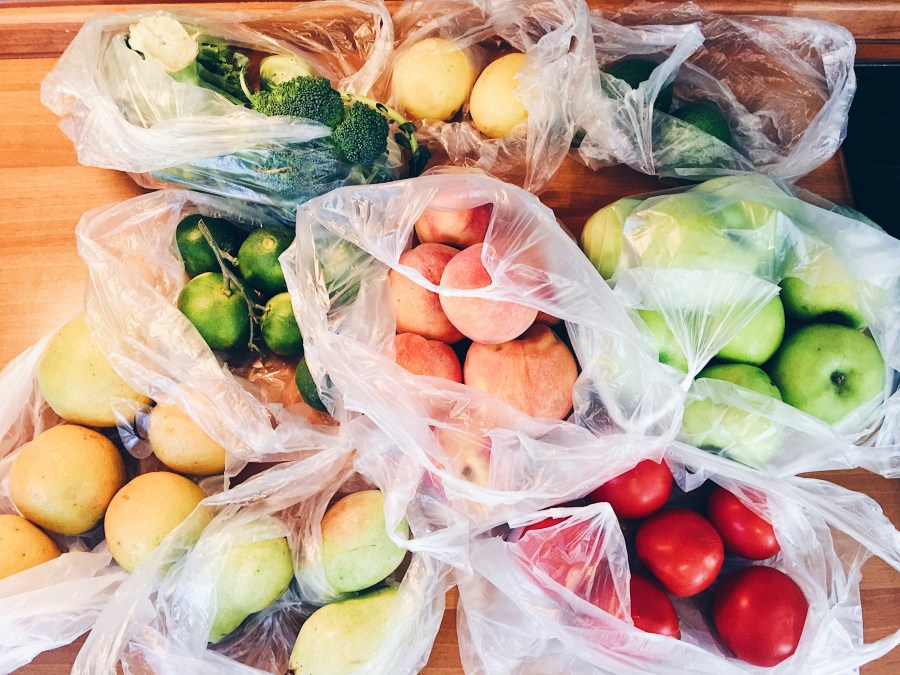 Apples, peachs, tomatoes, pears, cucumbers, avocado packed in plastic bags after shopping at local eco market