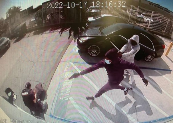 Two men are shown robbing a Loomis armored car driver on Oct. 17, 2022, in this photo provided by the U.S. Department of Justice.