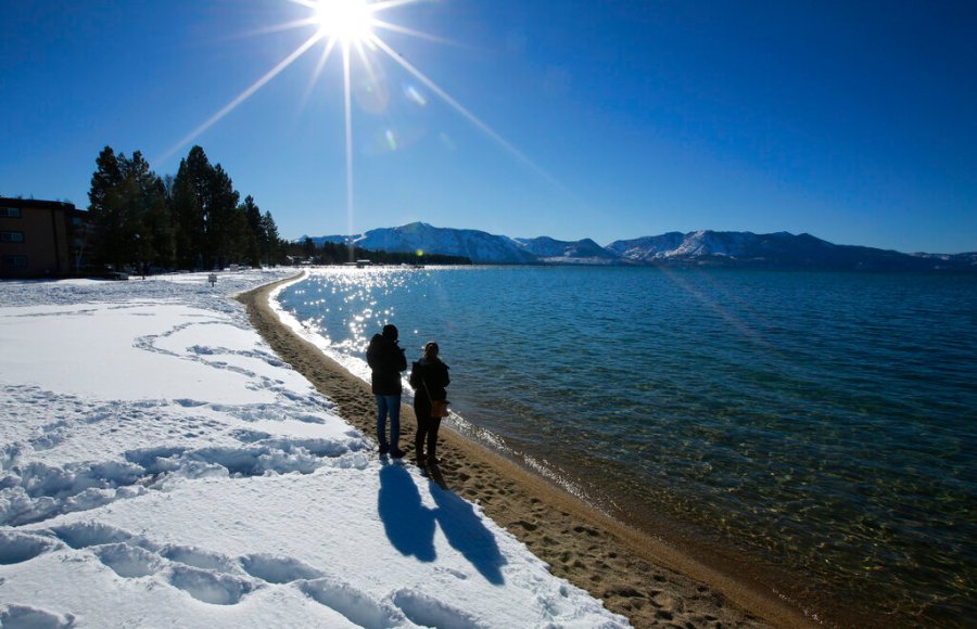 FILE - In this March 5, 2018, file photo, sunlight shimmers off the snow and waters of Lake Tahoe in South Lake Tahoe, Calif. (AP Photo/Rich Pedroncelli, File)