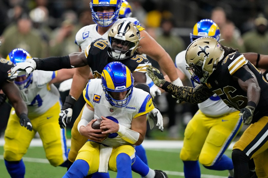 Los Angeles Rams quarterback Matthew Stafford is sacked by New Orleans Saints defenders Tanoh Kpassagnon (90) and Demario Davis (56) in the second half of an NFL football game in New Orleans on Nov. 20, 2022. (Gerald Herbert/Associated Press)