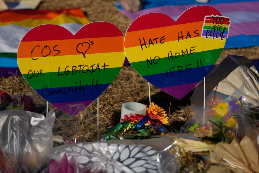 Heart-shaped signs bear messages of support in a makeshift memorial to the victims of a weekend mass shooting at a nearby gay nightclub on Tuesday, Nov. 22, 2022, in Colorado Springs, Colo. Anderson Lee Aldrich opened fire at Club Q, in which five people were killed and others suffered gunshot wounds before patrons tackled and beat the suspect into submission. (AP Photo/David Zalubowski)