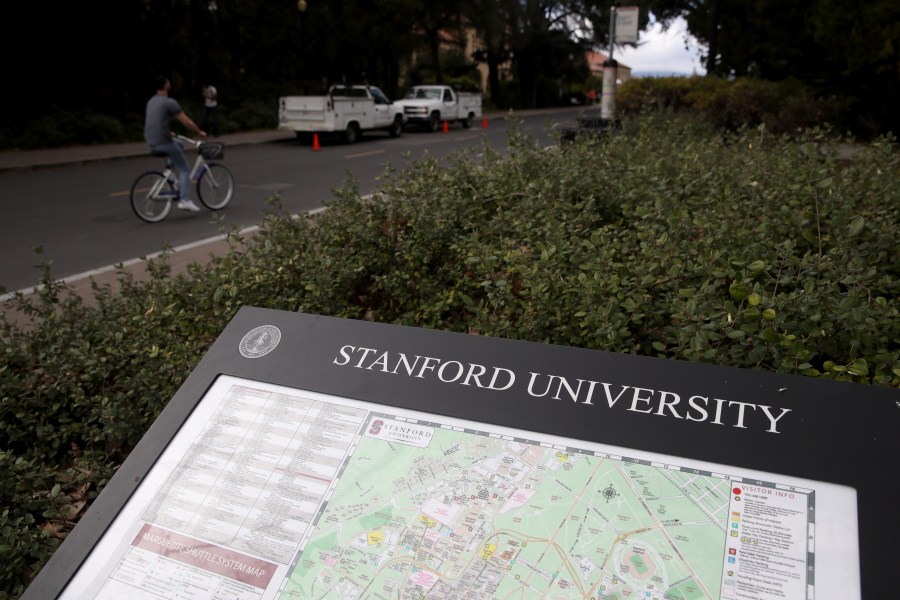 A cyclist rides by a map of the Stanford University campus on March 12, 2019 in Stanford, California (Justin Sullivan/Getty Images)