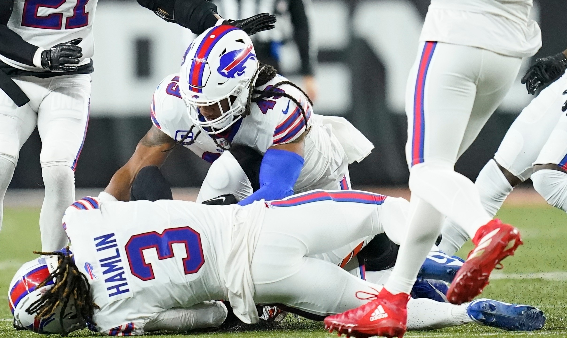 Buffalo Bills safety Damar Hamlin lies on the turf after making a tackle on Cincinnati Bengals wide receiver Tee Higgins, blocked from view, as Buffalo Bills linebacker Tremaine Edmunds assists at the end of the play during the first half of an NFL football game between the Cincinnati Bengals and the Buffalo Bills, Monday, Jan. 2, 2023, in Cincinnati. (AP Photo/Joshua A. Bickel)