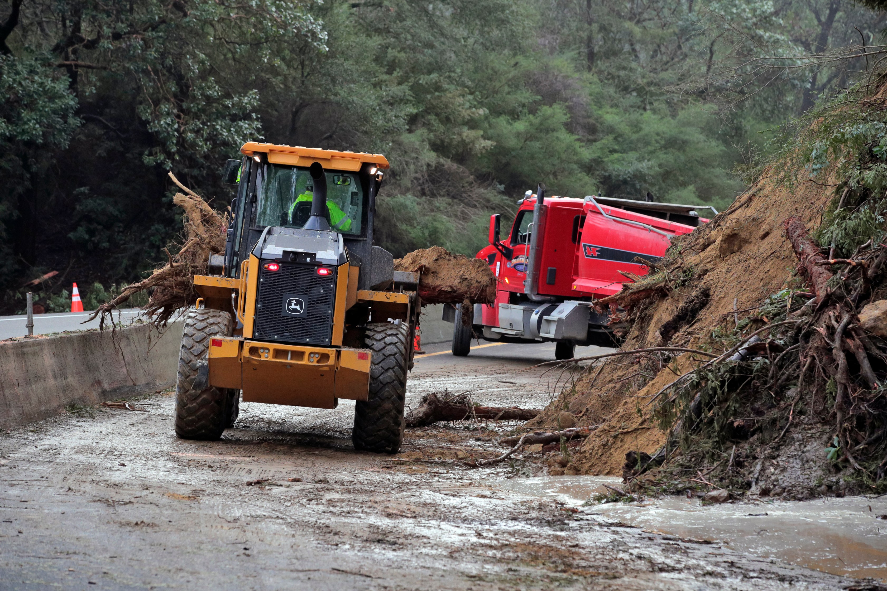 Caltrans crews work to clear a mudslide on Highway 17 that resulted from heavy rain from an atmospheric river storm in the Santa Cruz Mountains 1/4-mile south of Glenwood Drive in Scott's Valley, Calif., on Jan. 9, 2023. (Carlos Avila Gonzalez/San Francisco Chronicle via AP)