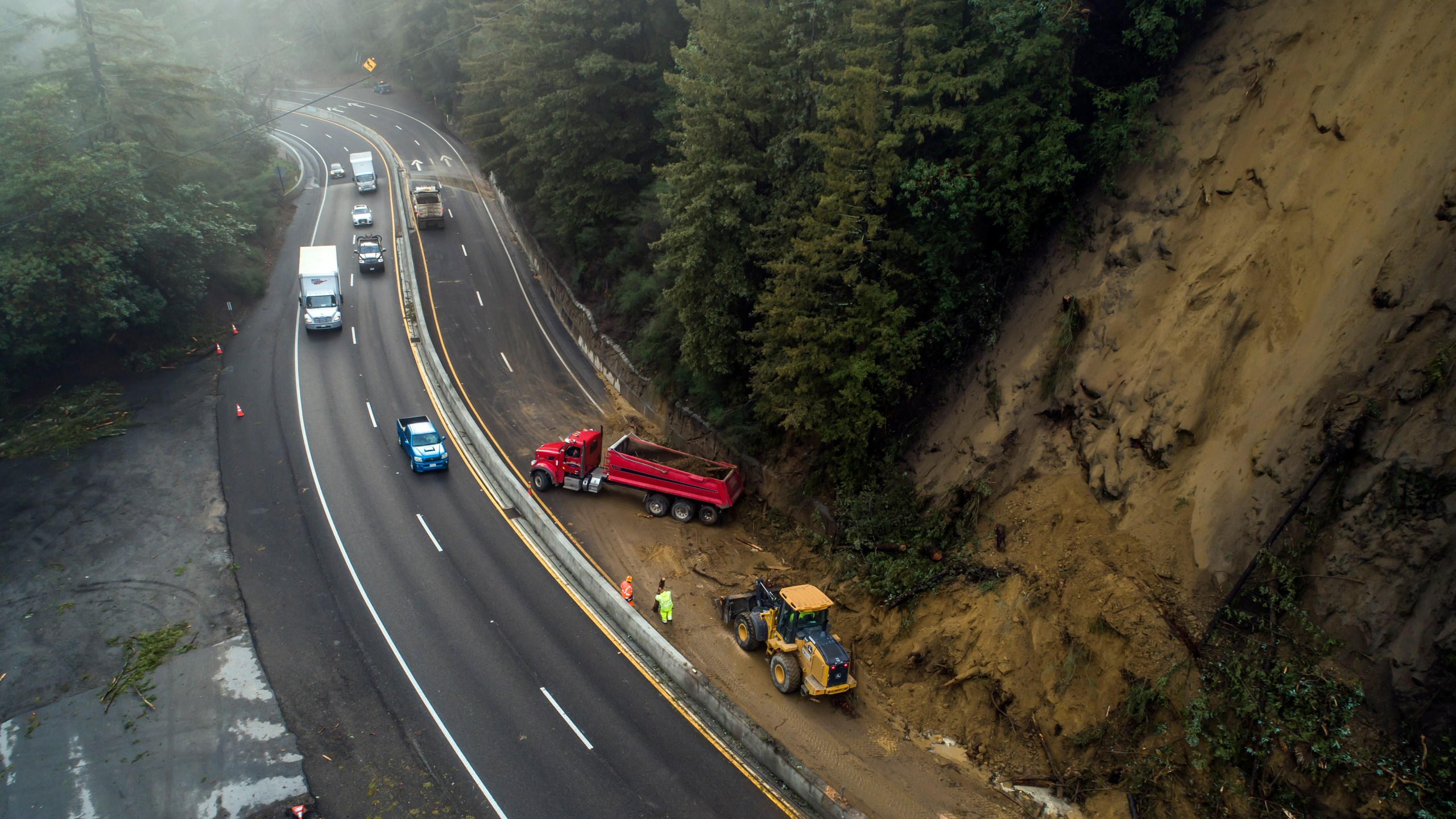 Caltrans crews work to clear a mudslide on Highway 17 that resulted from heavy rain from an atmospheric river storm in the Santa Cruz Mountains, south of Glenwood Drive in Scott's Valley, Calif. on Jan. 9, 2023. (Carlos Avila Gonzalez/San Francisco Chronicle via AP)