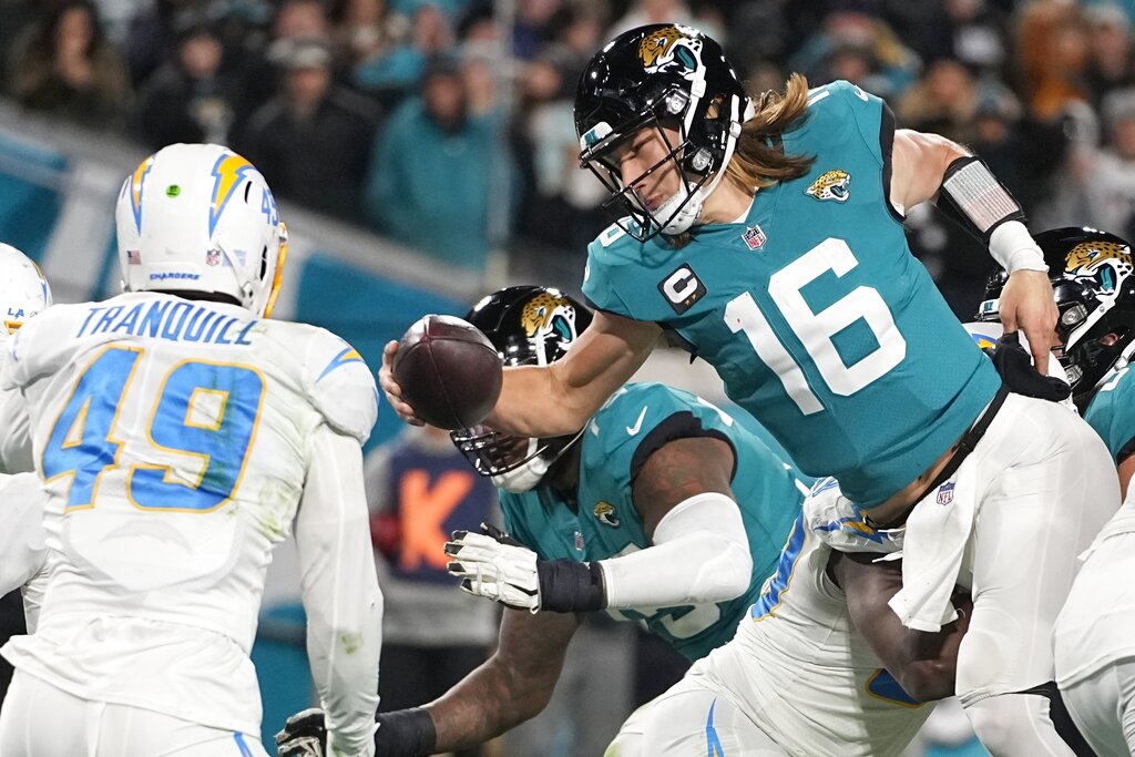 Jacksonville Jaguars quarterback Trevor Lawrence (16) leaps for a two-point conversion against the Los Angeles Chargers during the second half of an NFL wild-card football game, Saturday, Jan. 14, 2023, in Jacksonville, Florida.