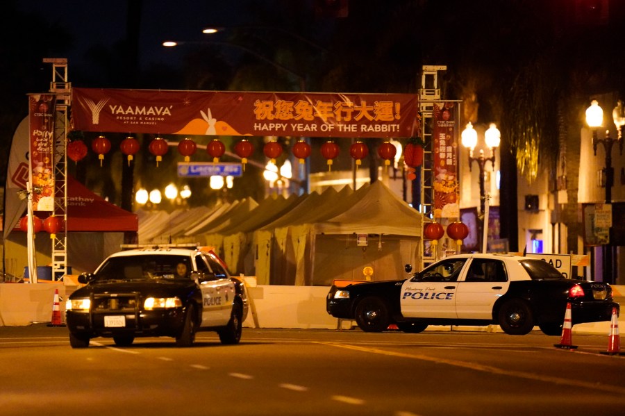 Two police vehicles are seen near a building where a shooting occurred in Monterey Park, Calif., Sunday, Jan. 22, 2023. Nine people were killed in a mass shooting late Saturday in a city east of Los Angeles following a Lunar New Year celebration that attracted thousands, police said. (AP Photo/Jae C. Hong)