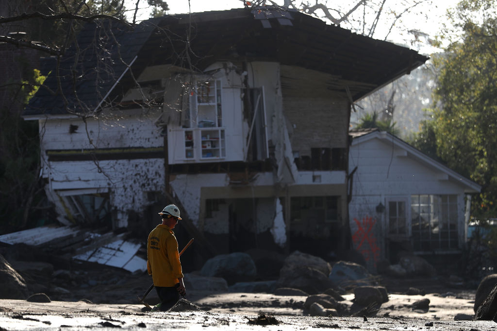 An urban search and rescue team member walks by a home that was destroyed by a mudslide on January 11, 2018 in Montecito, California. 17 people have died and hundreds hundreds of homes have been destroyed or damaged after massive mudslides crashed through Montecito, California early Tuesday morning. (Photo by Justin Sullivan/Getty Images)