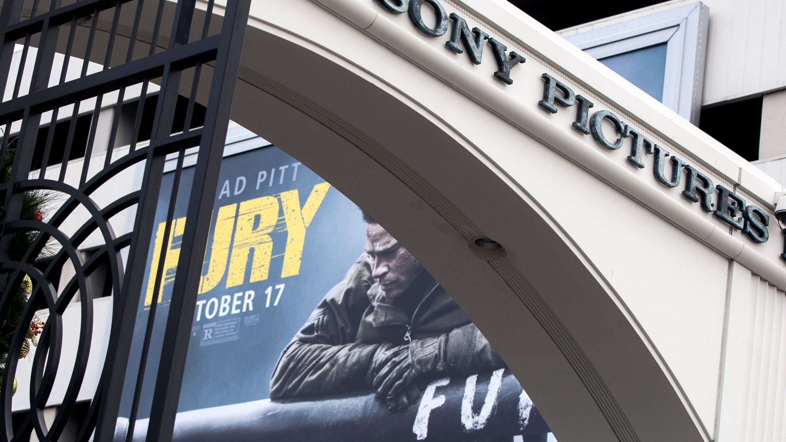 In this Dec. 18, 2014, file photo, a movie billboard is displayed behind a Sony Pictures Entertainment Studio entrance in Culver City. (AP Photo/Damian Dovarganes, File)