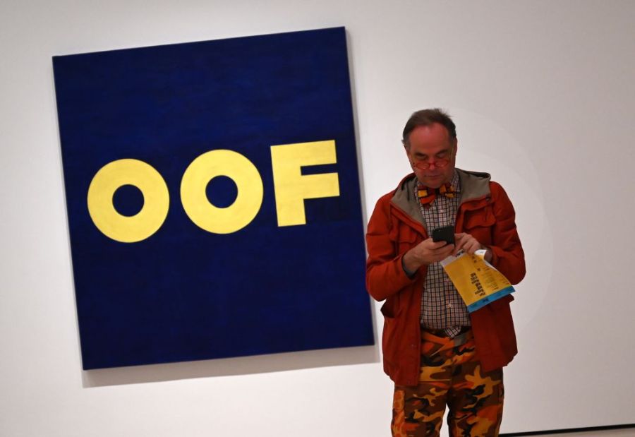 A member of the media stands next to Edward Ruscha "OOF" during a press preview on October 10, 2019, held for the expanded and re-imagined Museum of Modern Art (MOMA)  (Photo by TIMOTHY A. CLARY / AFP) 