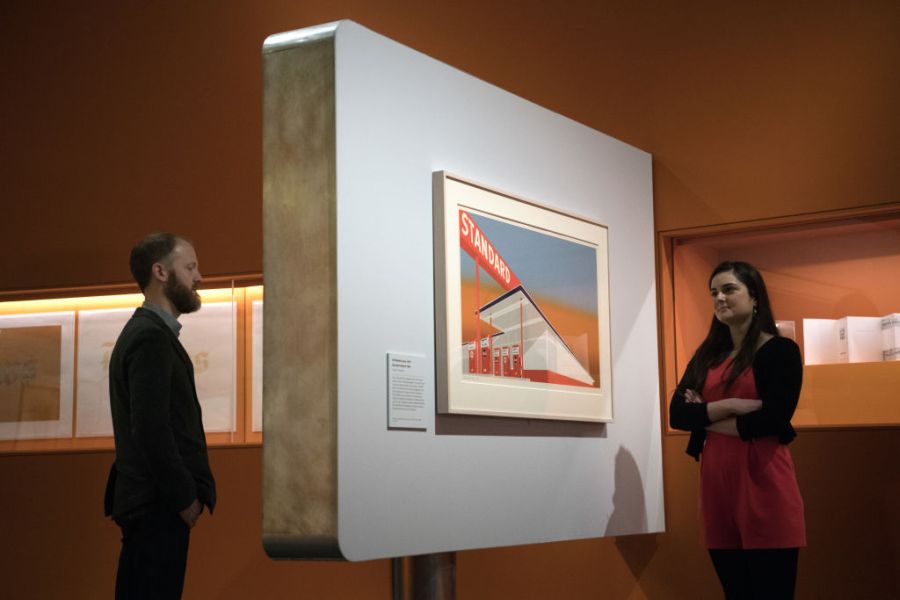 Staff members staff pose for photographers next to a work by Ed Ruscha entitled 'Standard Station 1966' during a press preview for the exhibition 'The American Dream: Pop To Present' at the British Museum on March 6, 2017 in London, England.   (Photo by Carl Court/Getty Images)