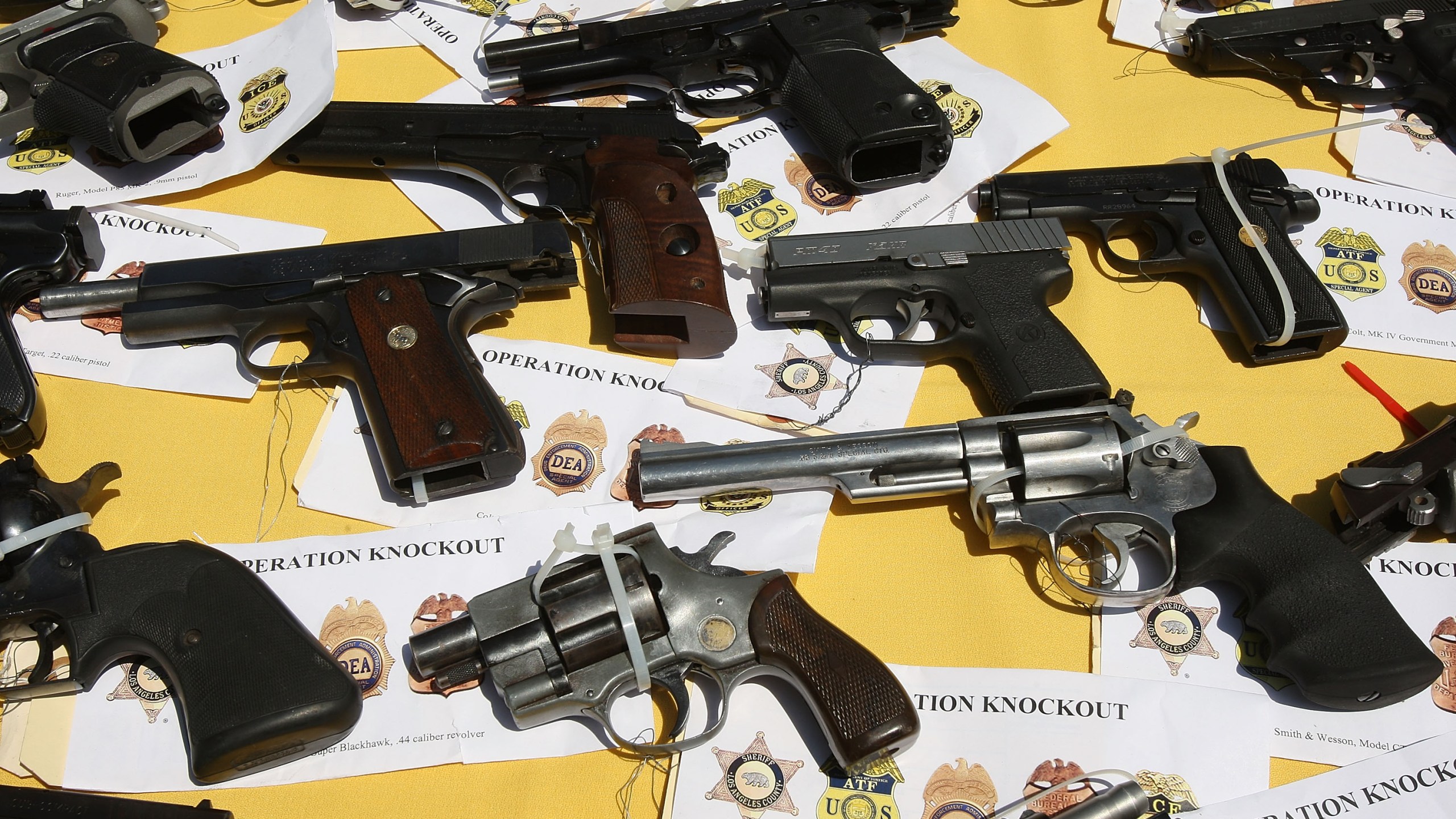 Some of about 125 weapons confiscated in a gang takedown are displayed at a press conference on May 21, 2009 in the Los Angeles-area community of Lakewood, California. (Photo by David McNew/Getty Images)