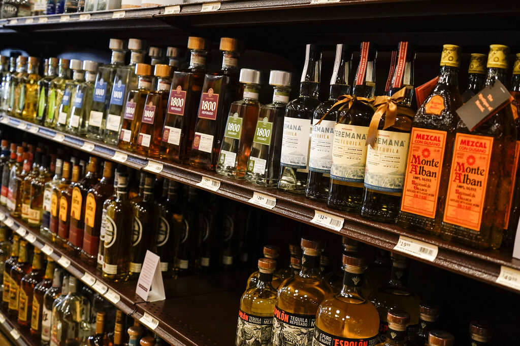 Shelves display bottles of tequila for sale at a fine wine and spirits store.