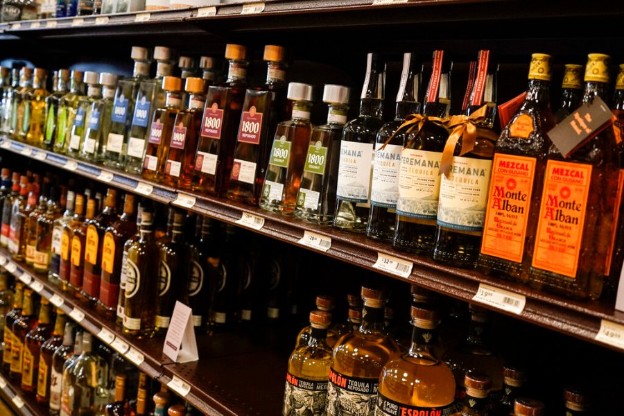 Shelves display bottles of tequila for sale at a fine wine and spirits store.