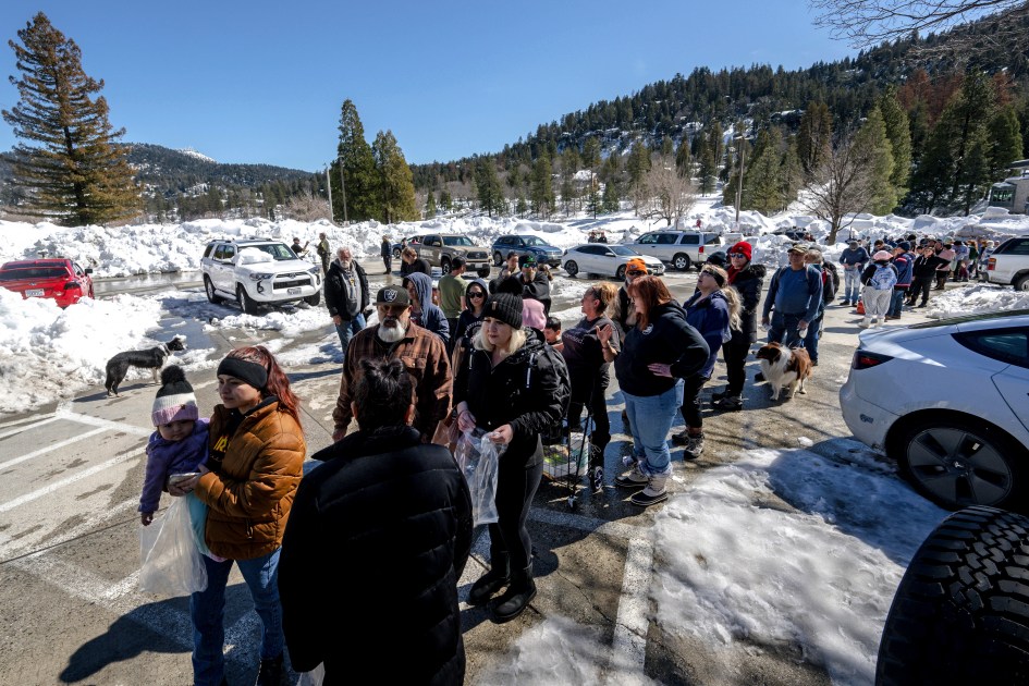 San Bernardino Mountain residents line up for a chance to get food at a tent in front of the Goodwin & Son's Market in Crestline, Calif., Friday, March 3, 2023, following a huge snowfall that buried homes and businesses. (Watchara Phomicinda/The Orange County Register via AP)