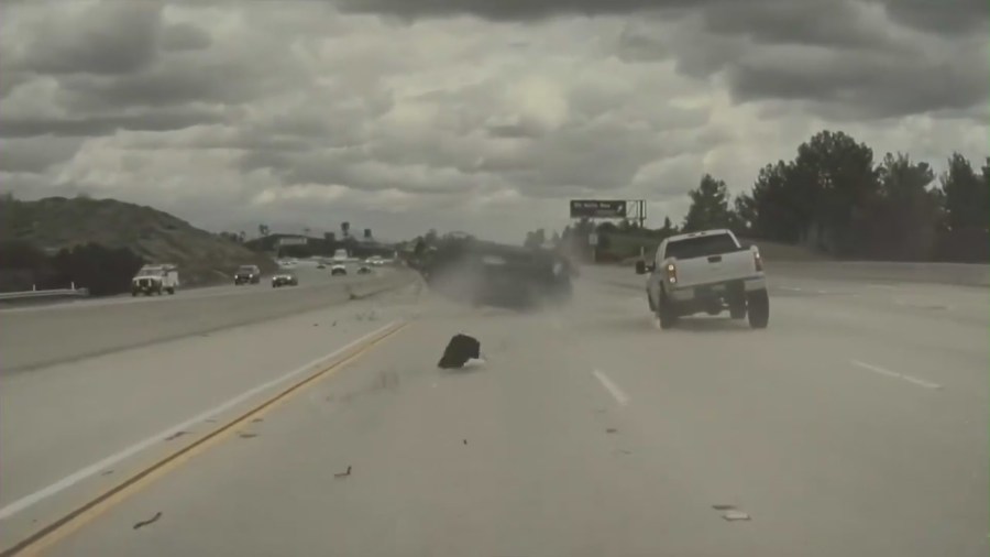 Dash-cam footage from a Tesla captured the moment a vehicle on the 118 Freeway in Chatsworth ran over a tire that had just come off a nearby pickup truck, launching the car into a midair spin on Mar. 23, 2023. (Anoop Khatra)