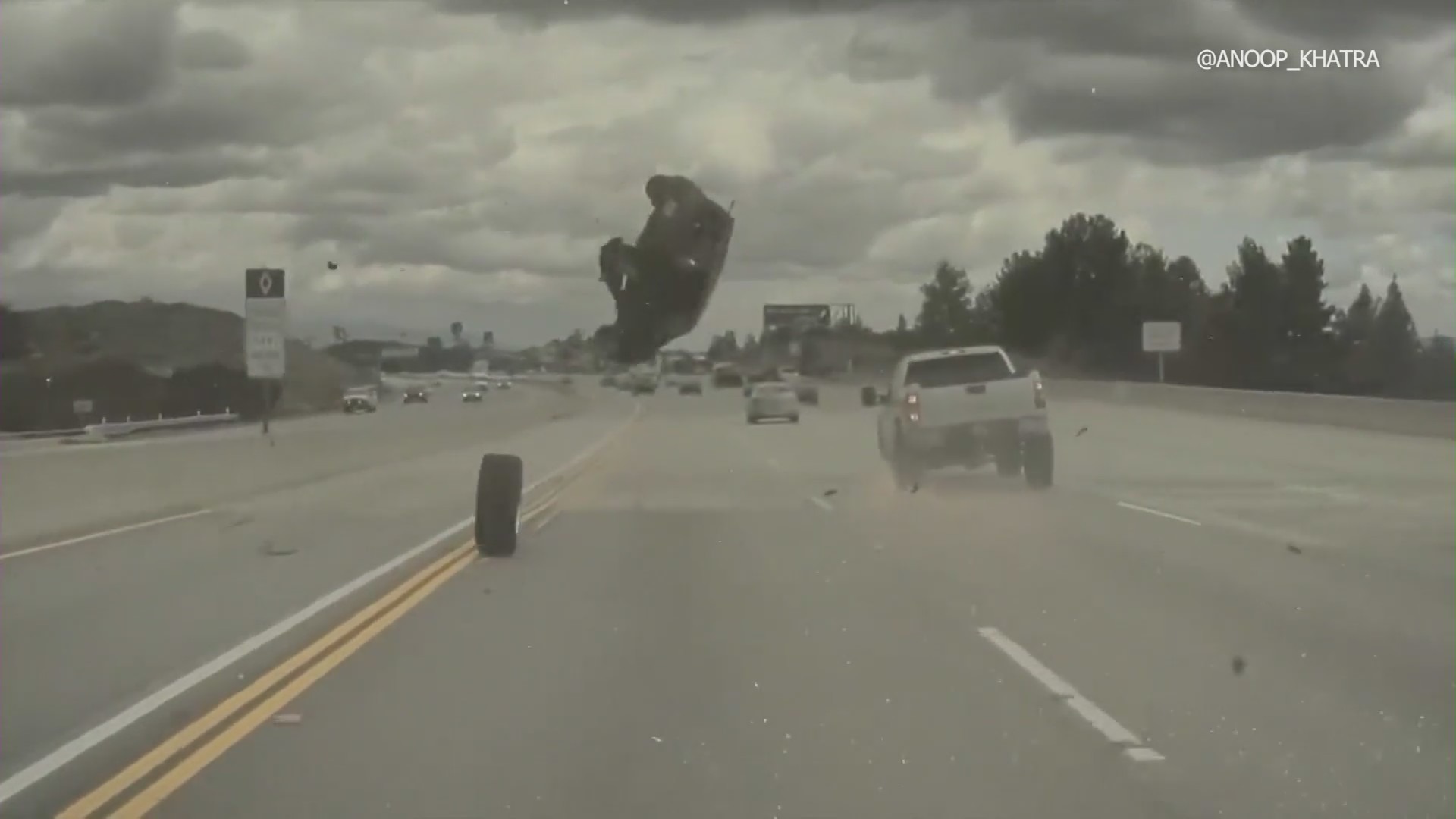 Dash-cam footage from a Tesla captured the moment a vehicle on the 118 Freeway in Chatsworth ran over a tire that had just come off a nearby pickup truck, launching the car into a midair spin on Mar. 23, 2023. (Anoop Khatra)