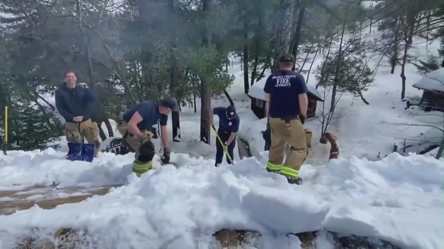 Orange County Fire Authority crews dig out homes and roads after a historic winter snowstorm in San Bernardino County mountain communities. (KTLA)