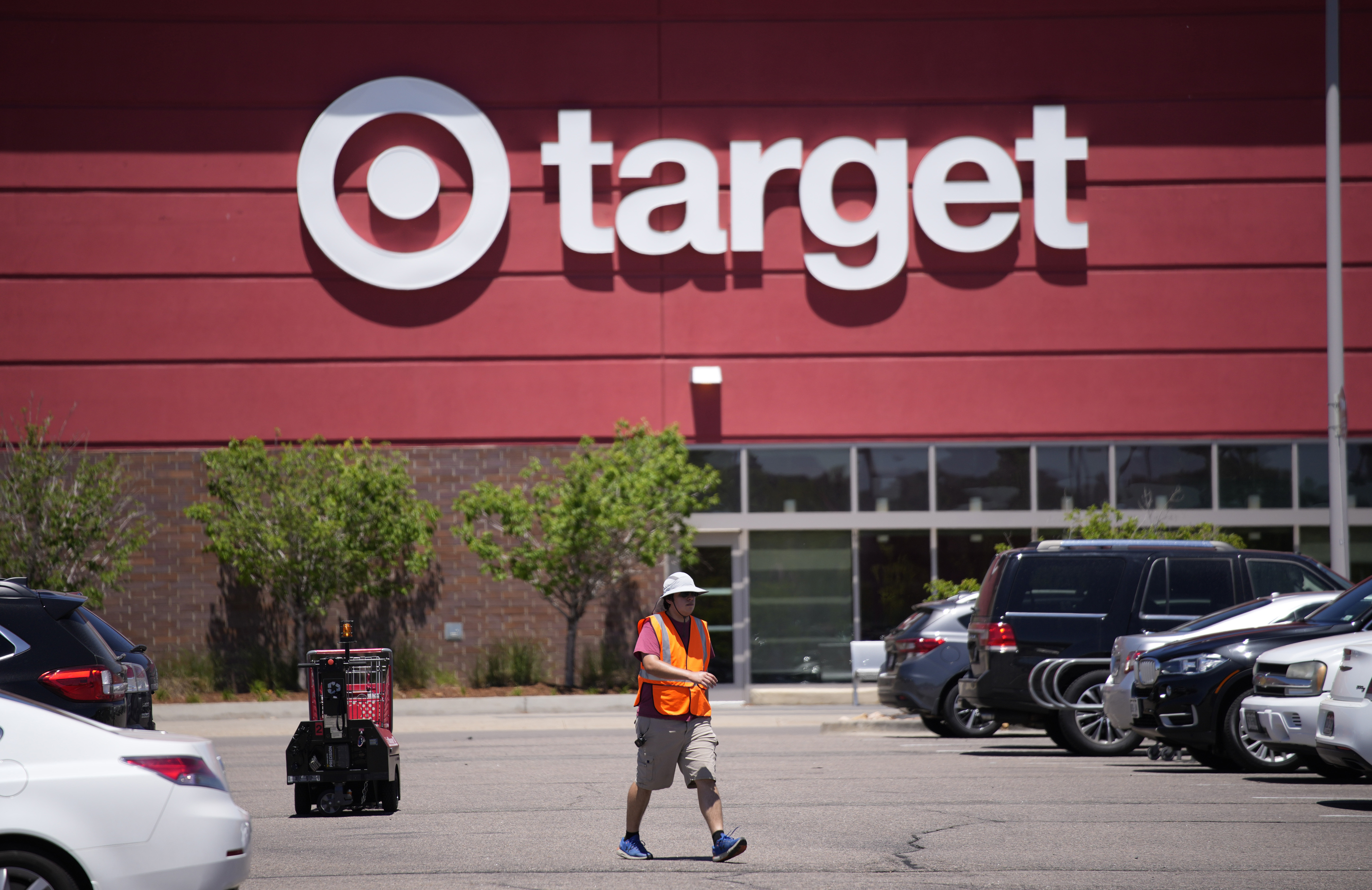 A worker collects shopping carts in the parking lot of a Target store on June 9, 2021. (AP Photo/David Zalubowski, File)