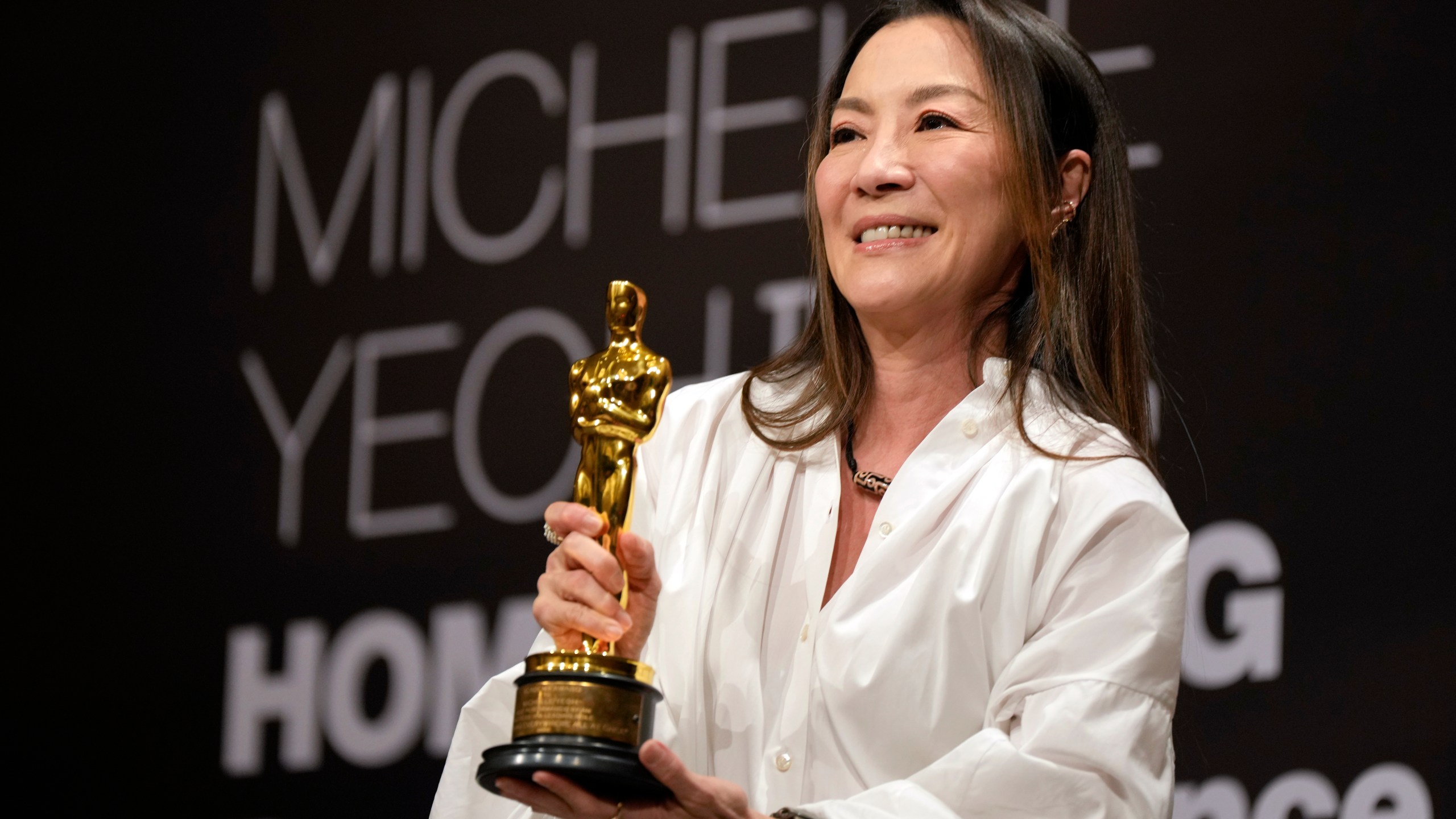 Malaysian actress Michelle Yeoh holds up the Oscar statuette during a press conference in Kuala Lumpur, Malaysia, Tuesday, April 18, 2023. Yeoh won the award for best performance by an actress in a leading role for "Everything Everywhere All at Once" at the Oscars on March 12. (AP Photo/Vincent Thian)