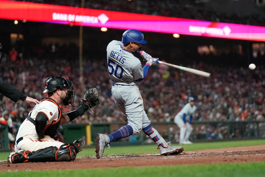 Los Angeles Dodgers' Mookie Betts (50) hits an RBI single in front of San Francisco Giants catcher Joey Bart during the seventh inning of a baseball game in San Francisco, Monday, April 10, 2023. (AP Photo/Jeff Chiu)