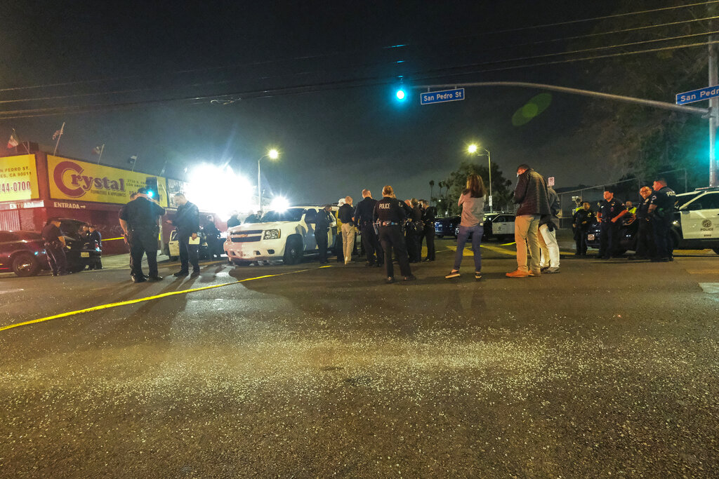 Police investigators gather after illegal fireworks seized at a South Los Angeles home exploded, in South Los Angeles Wednesday evening, June 30, 2021. A cache of the illegal fireworks exploded, damaging nearby homes and cars and causing injuries, authorities said. (AP Photo/Ringo H.W. Chiu)