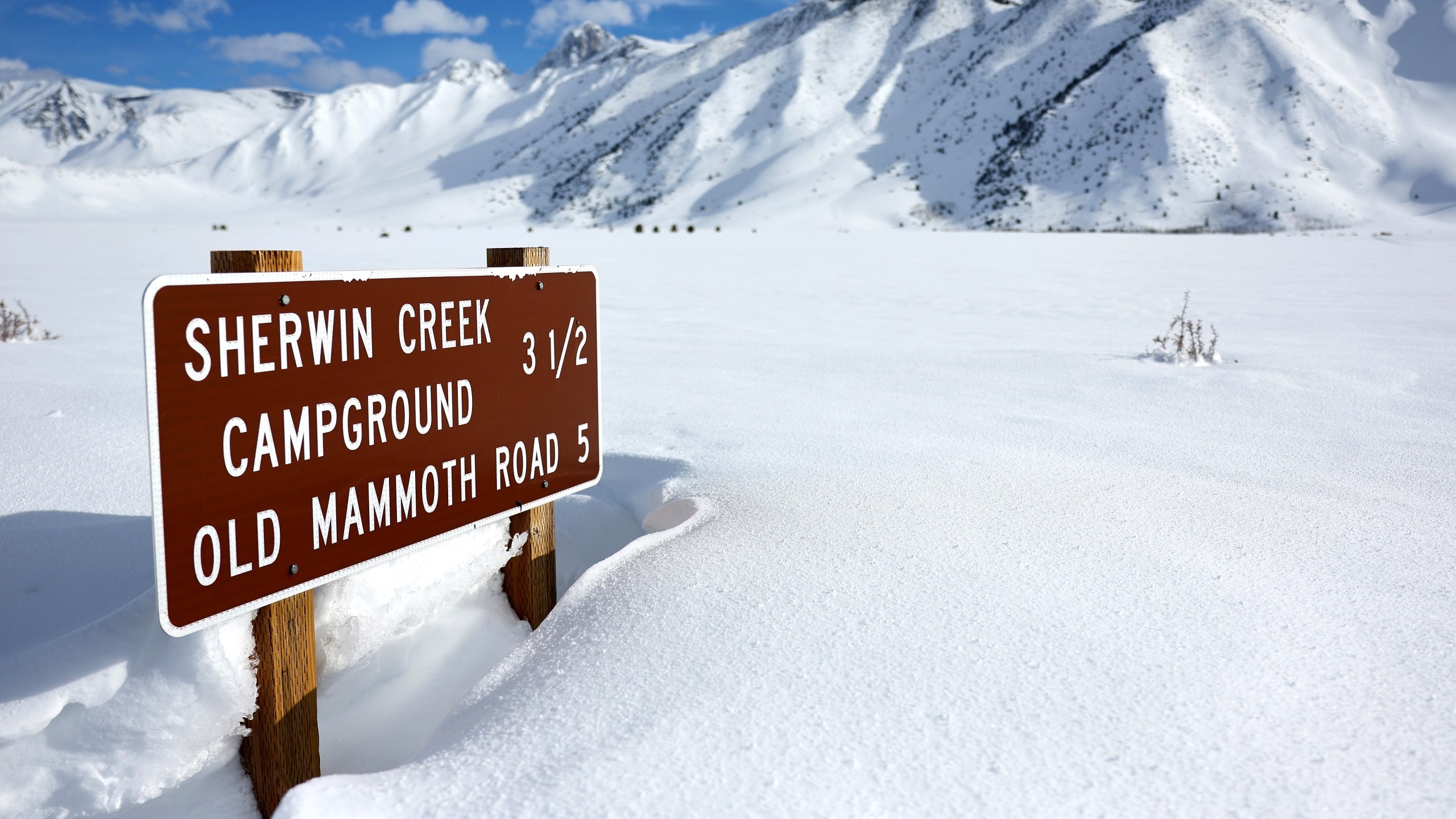 A road sign is partially buried in snow in the Sierra Nevada mountains after yet another storm system brought heavy snowfall to higher elevations further raising the snowpack on March 30, 2023 near Mammoth Lakes, California. (Mario Tama/Getty Images)