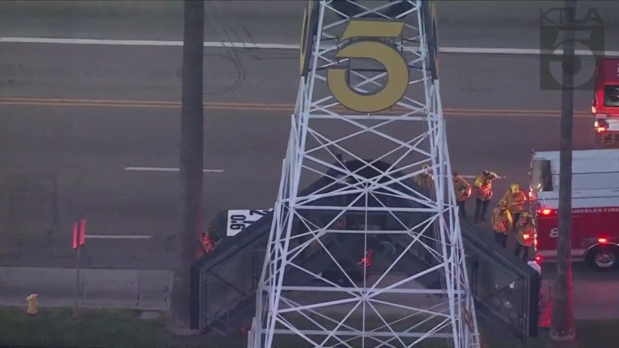 A man was seen climbing the KTLA 5 radio tower in Hollywood while holding a sign that read, “Free Billie Eilish” as authorities worked to remove him on April 25, 2023. (KTLA)