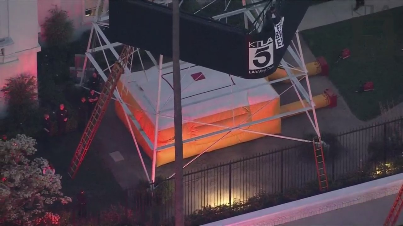 A man was seen climbing the KTLA 5 radio tower in Hollywood while holding a sign that read, “Free Billie Eilish” as authorities worked to remove him on April 25, 2023. (KTLA)